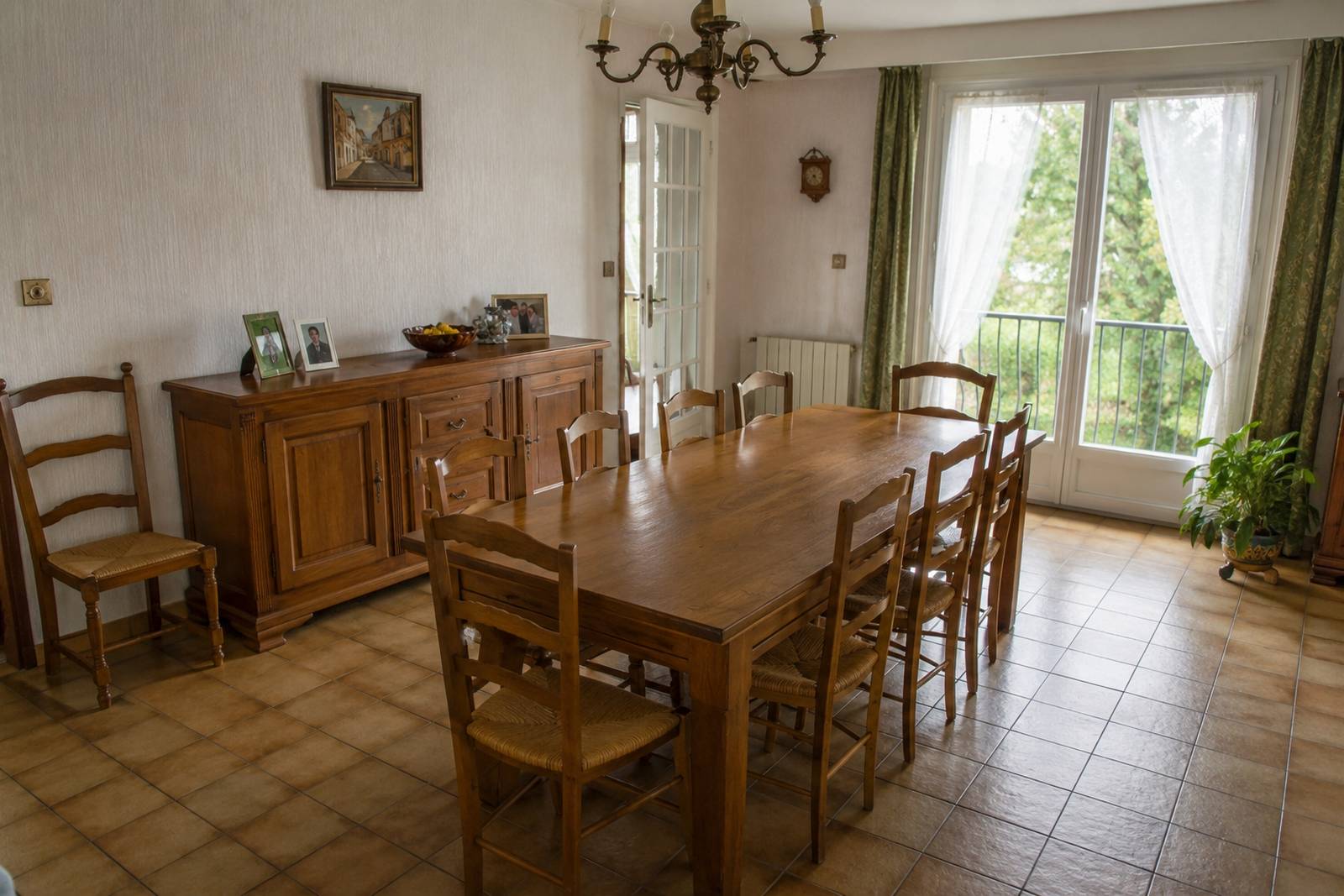 Salle à manger familiale avec grande table en bois et lumière naturelle.